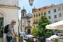 Turista em varanda para rua de Lisboa